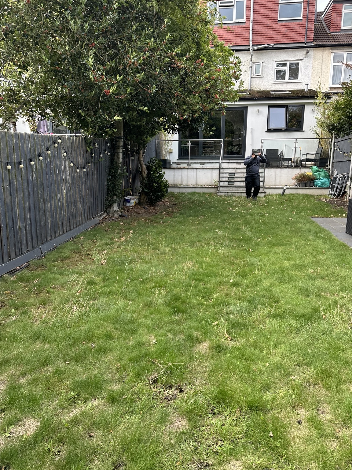 Garden before renovation, with older fencing and worn lawn